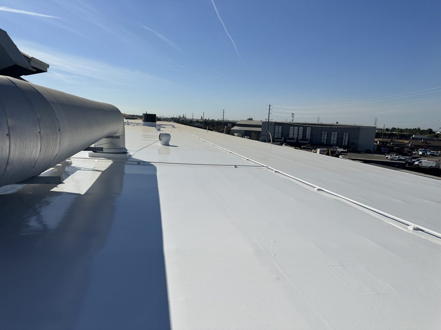 White commercial rooftop with HVAC ductwork