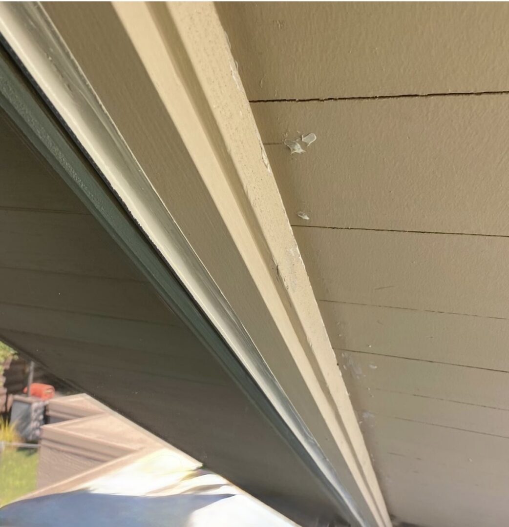 Peeling paint on beige house eaves