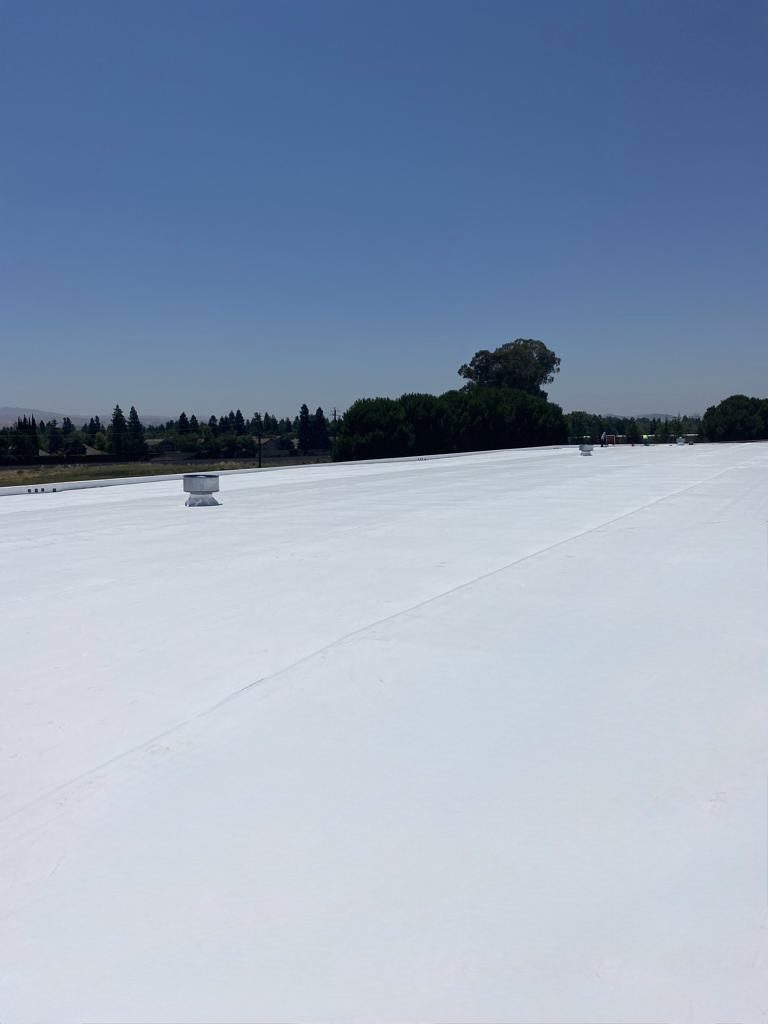 Expansive white rooftop with clear blue sky