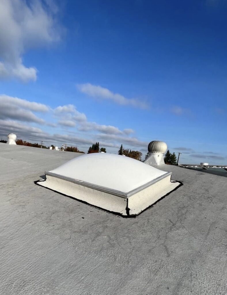 White domed skylight on flat commercial roof